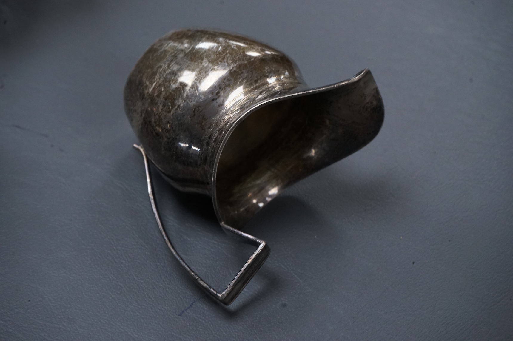 A late Victorian silver mounted lobed glass biscuit barrel by Hukin & Heath, with patent handle, London, 1899, height 14.4cm excluding the handle, together with a silver two handled condiment, a silver sugar bowl and a s